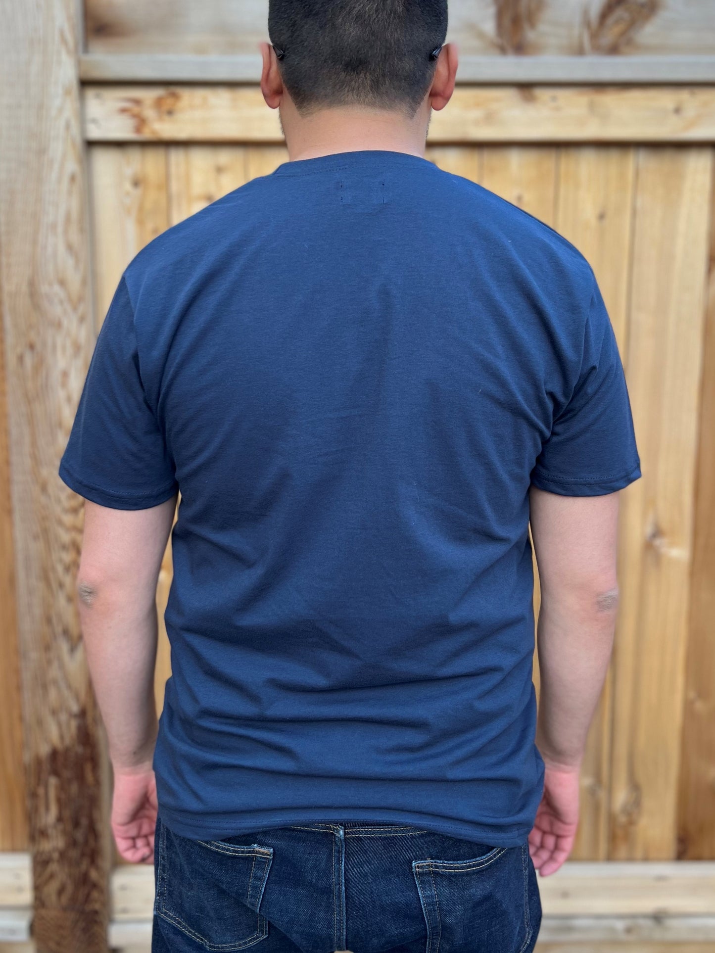 The back of a navy t-shirt worn by a man.
