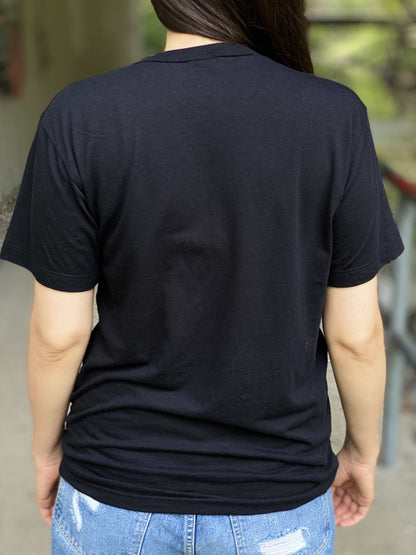 Back view of a black unisex bamboo t-shirt on a woman