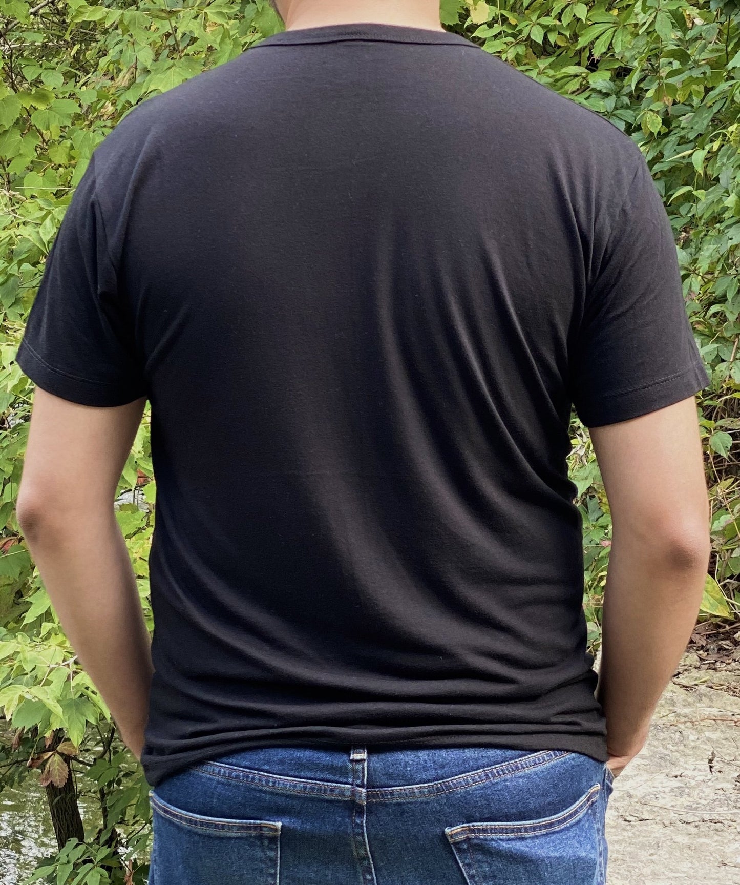 Back view of black bamboo unisex t-shirt on a man