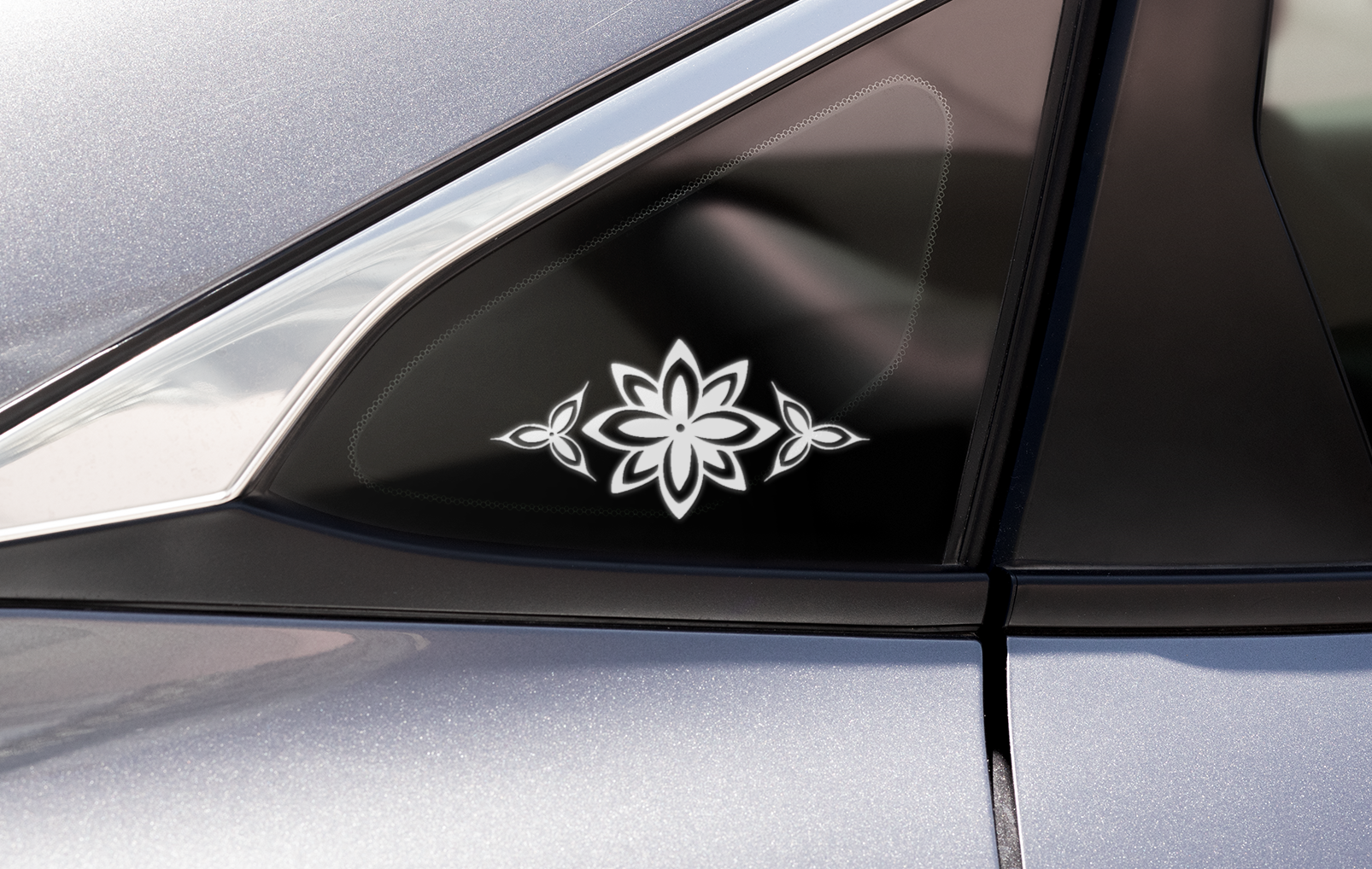 A white stylized flower decal on a car window 