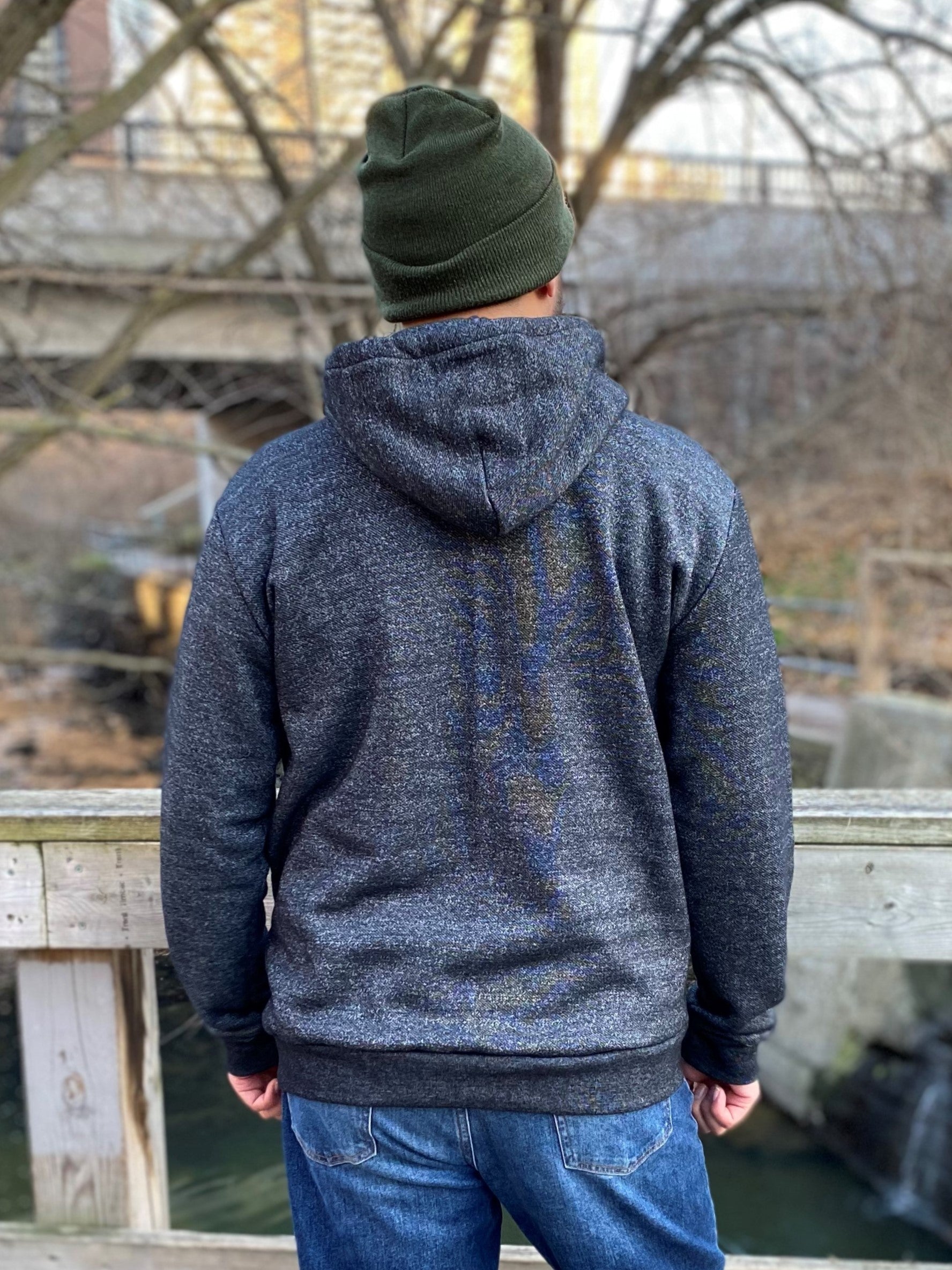 Back view of a man wearing a salt and pepper hoodie and green toque