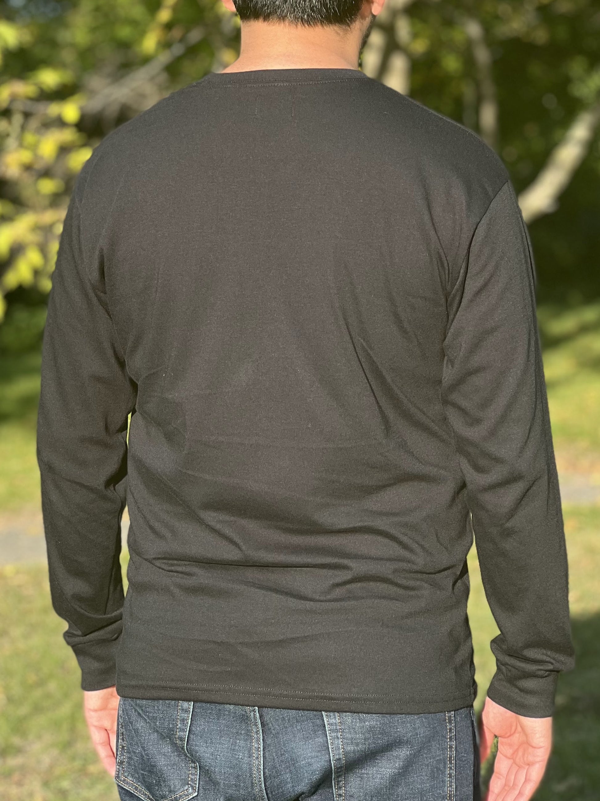 Back view of a man wearing a long-sleeved black t-shirt.