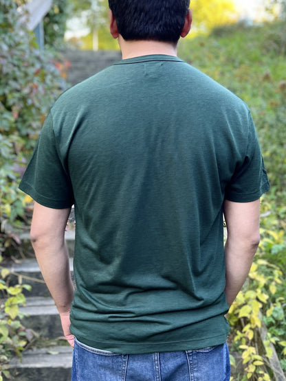 Back view of a man wearing a forest green t-shirt