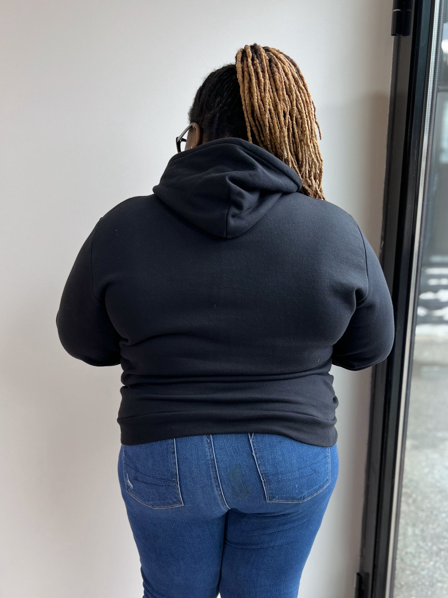 Back view of a woman wearing a black hoodie.