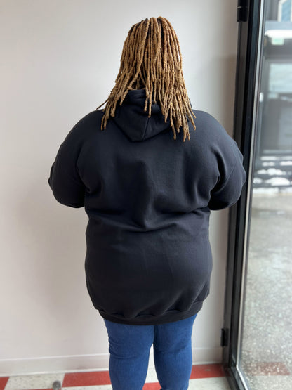 Back view of a woman wearing a a black hoodie.