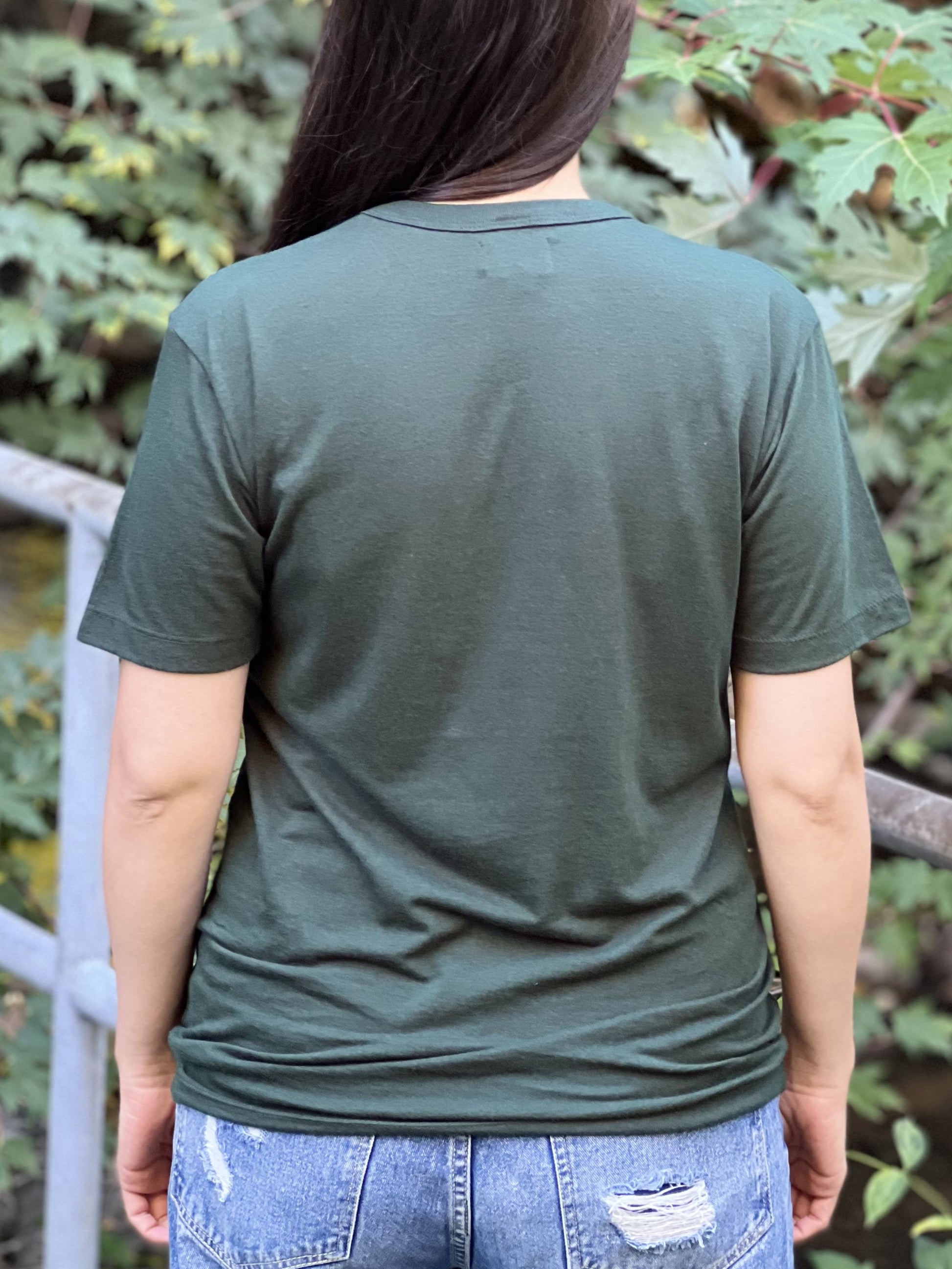 Back view of a woman wearing a forest green t-shirt